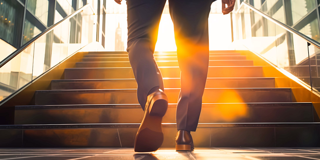 En mand bestiger en trappe som symbol for karriereudvikling