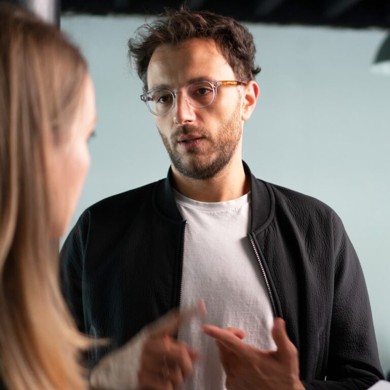 En mand står og snakker med en kvinde