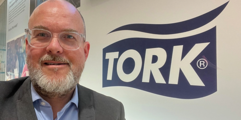 Andreas Normén står med en skylt av varumärket TOR i bakgrunden