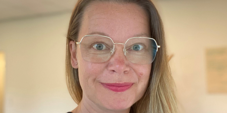 Lisa de paula med ett leende på läpparna och i glasögon